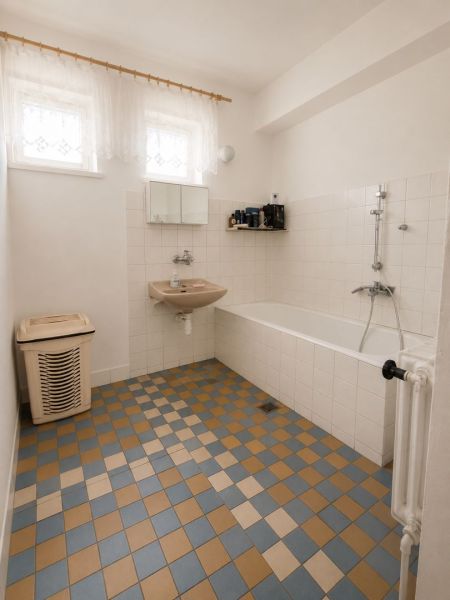 EXKLUZÍVNE LEN U NÁS! 4-izbový rodinný dom v obci Vydrany - Kúpeľňa v rodinnom dome s kachličkovou podlahou, vaňou, umývadlom a práčkovým košom.