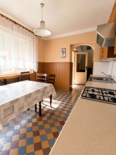 EXKLUZÍVNE LEN U NÁS! 4-izbový rodinný dom v obci Vydrany - Kuchyňa v rodinnom dome so vzorovanou dlažbou, jedálenským stolom a závesmi.