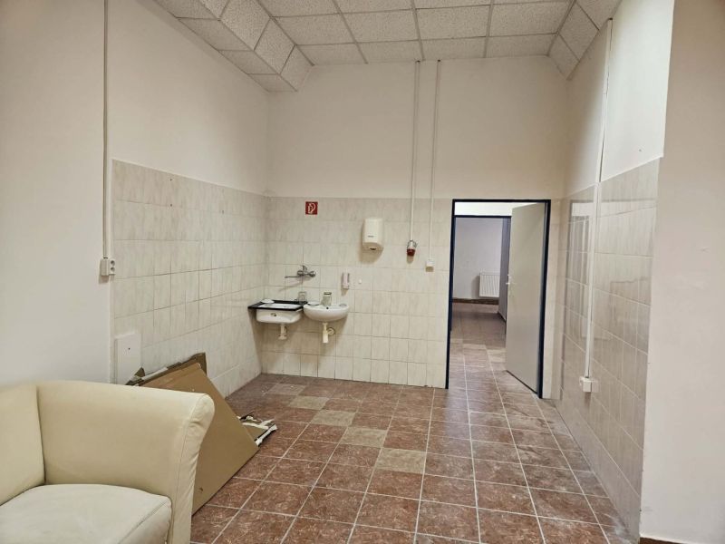 Exkluzívny obchodný priestor na prenájom v centre Dunajskej Stredy – u - Interiér obchodných priestorov s umývadlami, dlažbou a svetlým kreslom.