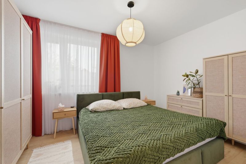 Exkluzívne na predaj – moderný 3-izbový byt so záhradou v Hornej Potôn - Spálňa v 3-izbovom byte s veľkou posteľou, závesmi a podlahou s dreveným dekorom.
