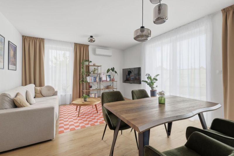 Exkluzívne na predaj – moderný 3-izbový byt so záhradou v Hornej Potôn - Obývačka v 3-izbovom byte s jedálenským stolom a podlahou s dreveným dekorom.