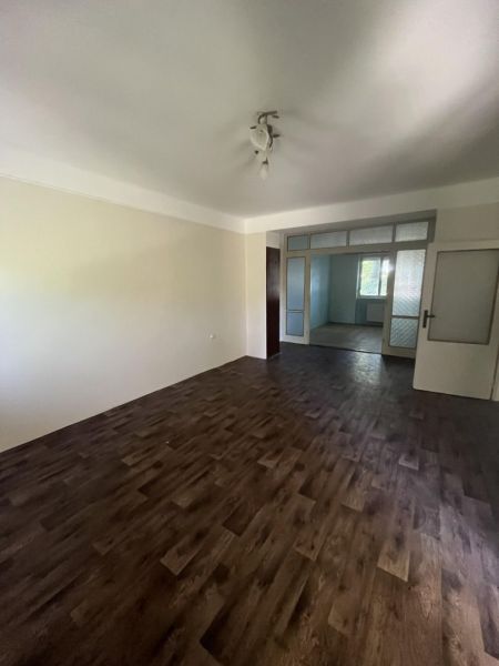 Nová ponuka – 3 izbový byt na predaj v Dunajskej Strede - Obývacia izba v 3-izbovom byte s podlahou s dreveným dekorom a svetlým osvetlením.