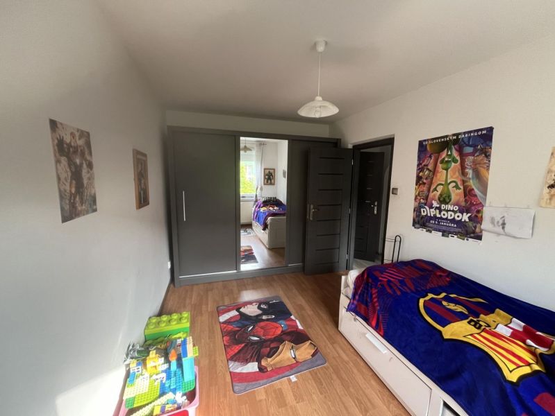 Nová Ponuka! 3 izbový byt na predaj v Dunajskej Strede - Detská izba so zrkadlovou skriňou, plagátmi, hračkami a podlahou s dreveným dekorom.