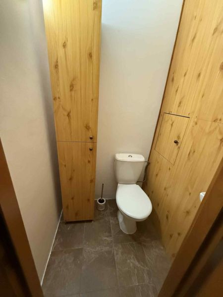 Prenájom 3izbového bytu v srdci Dunajskej Stredy - Toaleta so skrinkou, obklopená stenami s dreveným dekorom, kachličková podlaha.