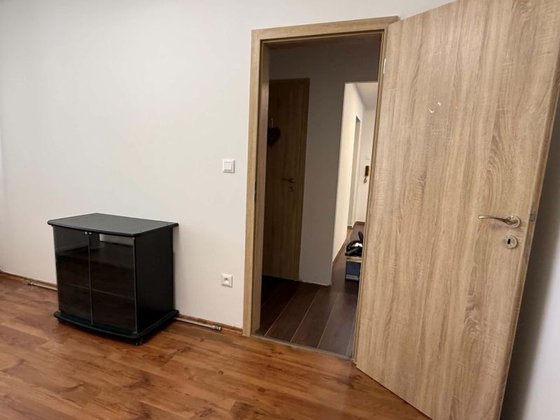 Predaj 3-izbového bytu, Dunajská Streda - Otváracie dvere a skrinka s podlahou s dreveným dekorom v 3-izbovom byte.