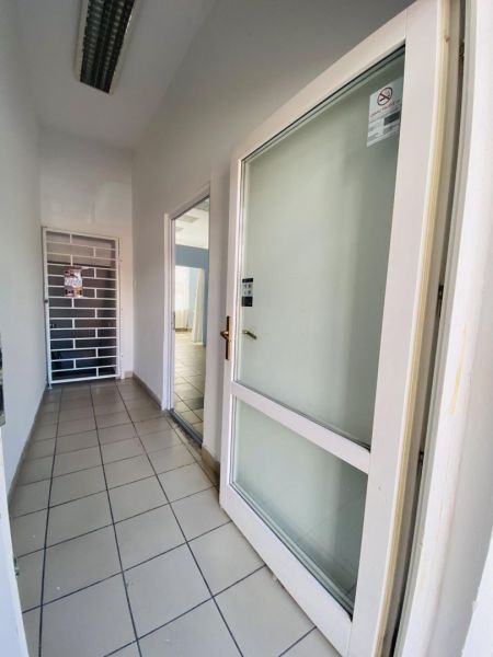 -Na prenájom obchodný priestor 30 m2 v centre mesta Dunajská Streda - Chodba s dlažbou v obchodných priestoroch, presklené dvere, kovová mreža.
