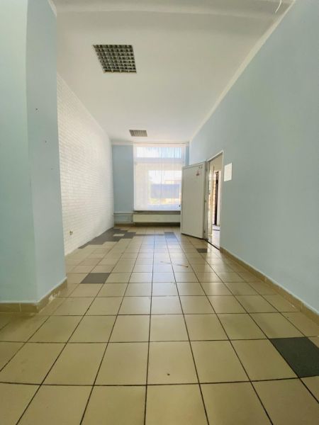 -Na prenájom obchodný priestor 30 m2 v centre mesta Dunajská Streda - Obchodné priestory s dlažbou, svetlomodrými stenami a veľkým oknom pred vstupom.
