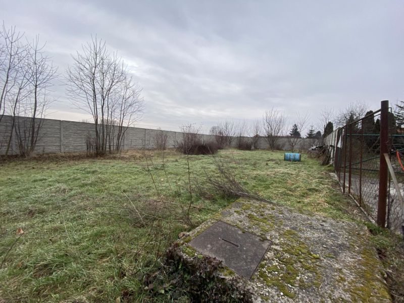 Na predaj stavebný pozemok na stavbu RD v Gabčíkove / 95 000,-EUR - Pozemky - bývanie v Gabčíkove: Neudržiavaná trávnatá plocha obklopená betónovým plotom a oplotením.