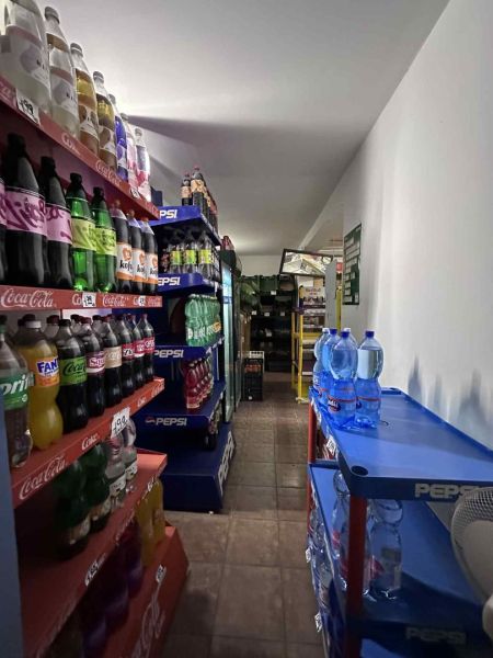 Znížená cena     Predaj – Obchodný priestor v Dunajskej Strede 100 000 - Regály s nápojmi v obchodných priestoroch; pohľad zúženou chodbou.