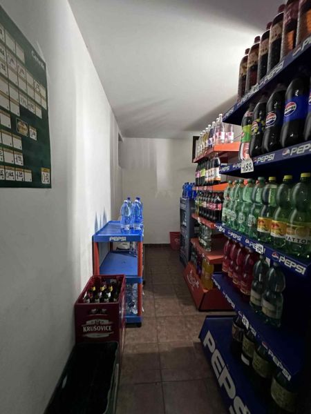 Znížená cena     Predaj – Obchodný priestor v Dunajskej Strede 100 000 - Obchodné priestory s regálmi plnými nealkoholických nápojov a krabicami piva.