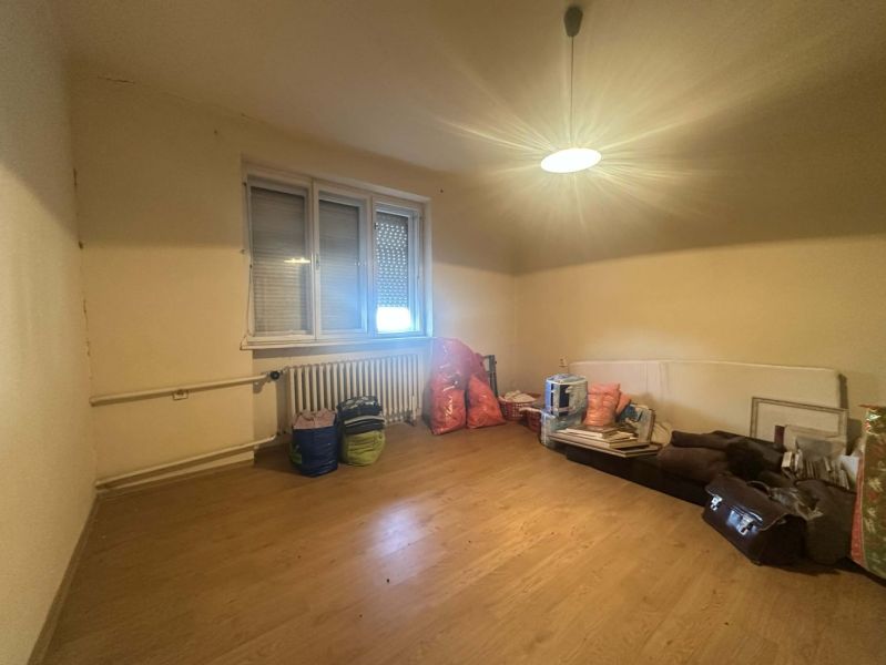 Rodinný dom s veľkým potenciálom v obci Dolný Štál – ideálny na bývani - Izba s podlahou s dreveným dekorom v rodinnom dome, stropné osvetlenie, okno s roletami.