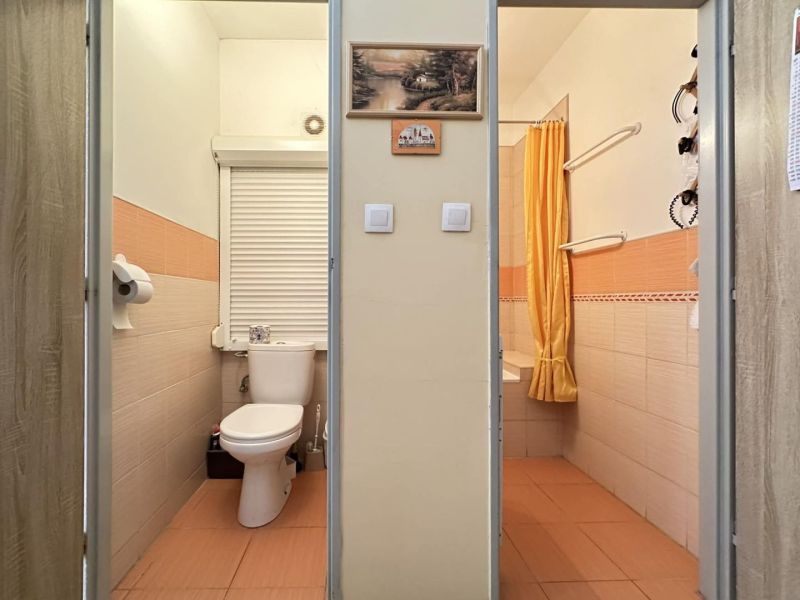REZERVOVANÉ   NOVÁ CENA !!!!  108000,-EUR  NA PREDAJ EXKLUZÍVNE  : 1  - Kúpeľňa v 1-izbovom byte s oranžovými obkladmi a závesom.
