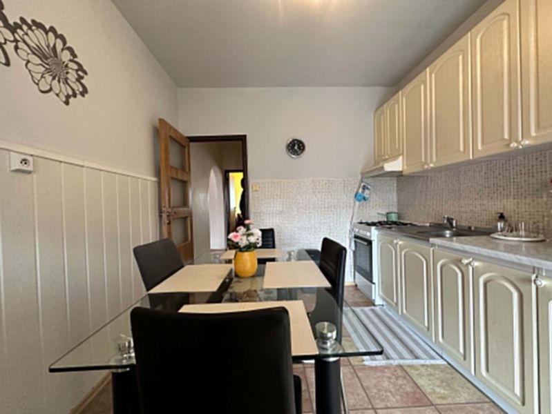 Na predaj kompletne zariadený 3 izbový byt s klimatizáciou aj s balkón - Kuchyňa v 3-izbovom byte s jedálenským stolom a svetlými skrinkami.