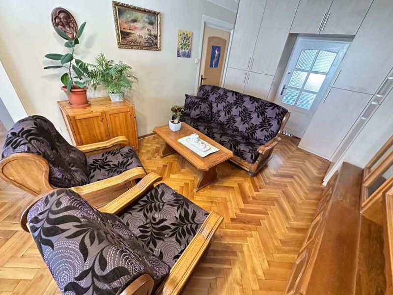 119 000,- €   ZNÍŽENÁ  CENA  Na predaj 3 izbový byt v Dunajskej Strede - Obývačka s podlahou s dreveným dekorom, kreslami a kvetmi v 3-izbovom byte.