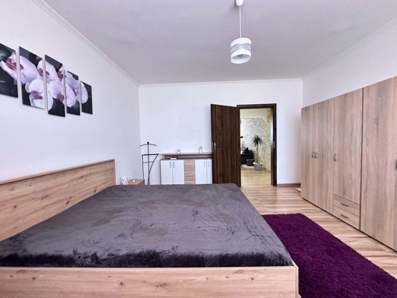 Na predaj priestranný, svetlý  a kompletne zariadený 3-izbový byt s lo - Spálňa s posteľou a skriňou v 3-izbovom byte, podlaha s dreveným dekorom.
