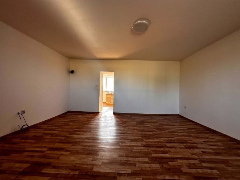 Na predaj 2-izb. byt v dvojdome (110 m²) v štandarde s krbom – Možnosť - Obývacia izba v rodinnom dome s podlahou s dreveným dekorom.