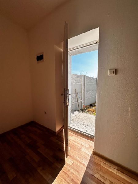 Na predaj 2-izb. byt v dvojdome (110 m²) v štandarde s krbom – Možnosť - Otvorené dvere z rodinného domu vedúce na dvor, s podlahou s dreveným dekorom.
