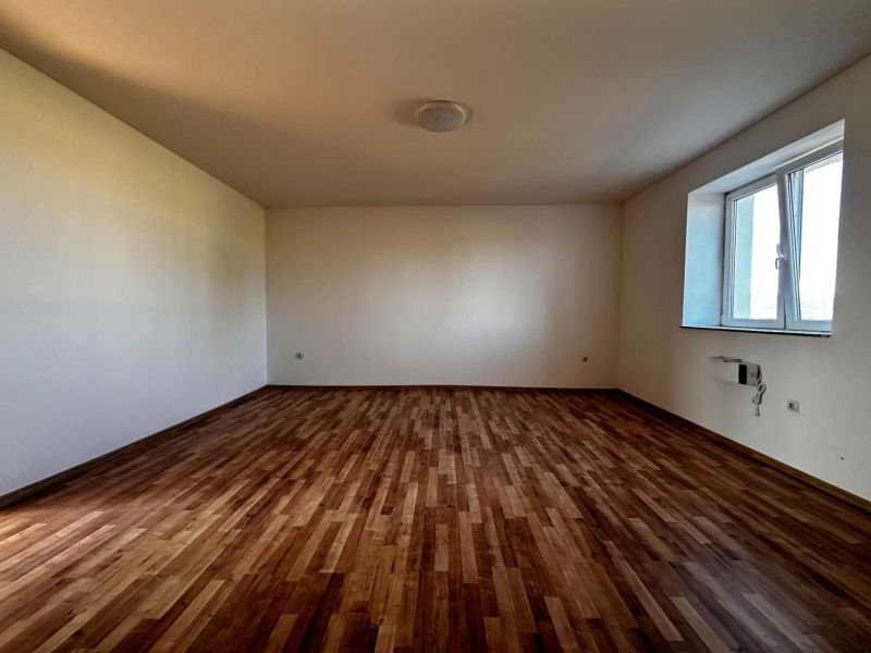 Na predaj 2-izb. byt v dvojdome (110 m²) v štandarde s krbom – Možnosť - Priestranná izba s podlahou s dreveným dekorom a veľkým oknom v rodinnom dome.