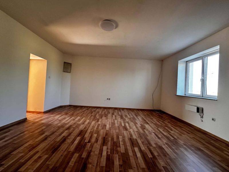Na predaj 2-izb. byt v dvojdome (110 m²) v štandarde s krbom – Možnosť - Izba v rodinnom dome s podlahou s dreveným dekorom a priestranným oknom.