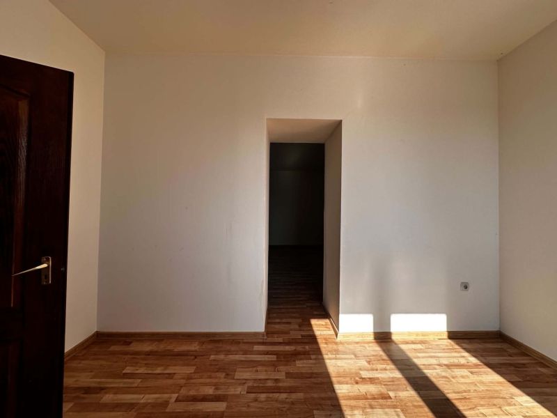Na predaj 2-izb. byt v dvojdome (110 m²) v štandarde s krbom – Možnosť - Svetlá miestnosť v rodinnom dome s podlahou s dreveným dekorom a otvorenými dverami.