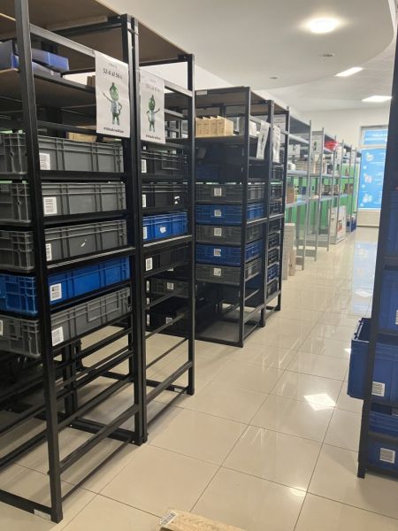 Prenájom obchodný priestor v centre mesta Dunajská Streda - Skladové regály s plastovými boxami v obchodných priestoroch s dlažbou na podlahe.