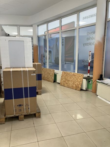 Prenájom obchodný priestor v centre mesta Dunajská Streda - Balenie na paletách v obchodných priestoroch, svetlá dlažba, výlohy s reklamným bannerom.