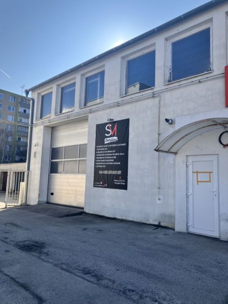 Prenájom skladový priestor v centre mesta + vlastné parkovanie - Budova v skladovom areáli v Dunajskej Strede s reklamou na detailing.