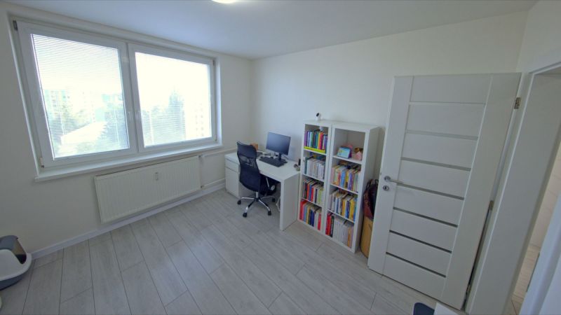 Na predaj 3 izbový byt, Trieda SNP, Terasa - Izba s pracovným stolom, knihovňou a podlahou s dreveným dekorom v 3-izbovom byte.