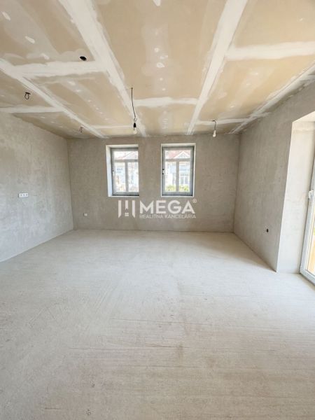 Na predaj rodinný dom v obci Nacina Ves - Priestranná izba v rodinnom dome s veľkými oknami a betónovou podlahou.