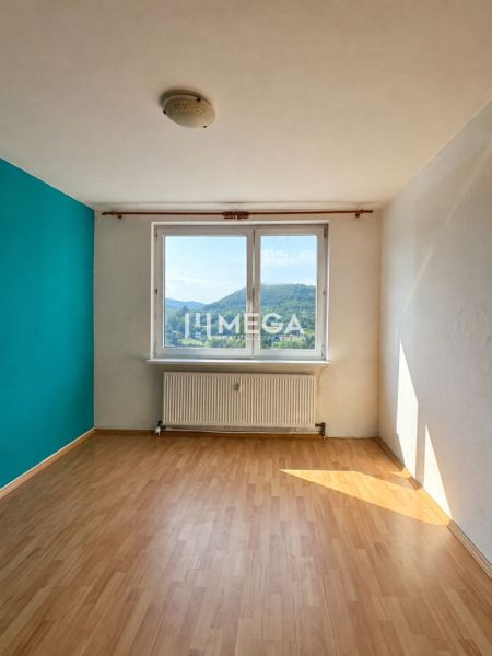 Na predaj 3 izbový byt s balkónom na Sidl.III v Humennom - Izba v 3-izbovom byte s podlahou s dreveným dekorom a výhľadom na krajinu.