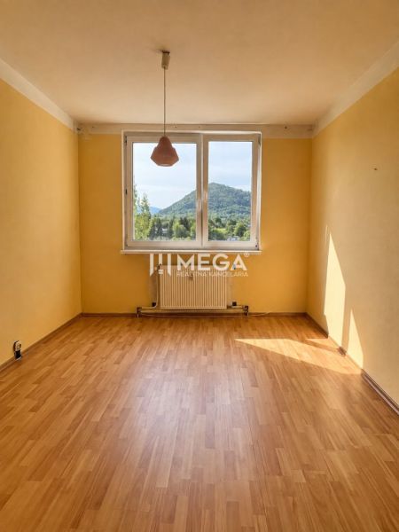 Na predaj 3 izbový byt s balkónom na Sidl.III v Humennom - Izba v 3-izbovom byte s podlahou s dreveným dekorom a veľkým oknom s výhľadom.