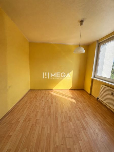 Na predaj 3 izbový byt s balkónom na Sidl.III v Humennom - Žltá miestnosť s veľkým oknom a podlahou s dreveným dekorom v 3-izbovom byte.