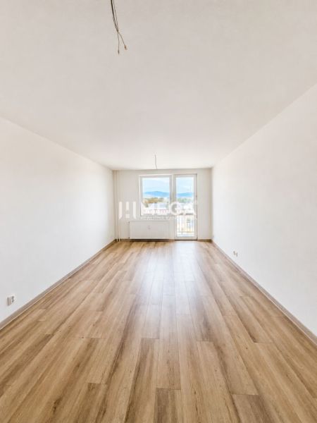 Na predaj  – 2 izbový byt s balkónom v Strážskom - Priestranná obývacia izba so vstupom na balkón a podlahou s dreveným dekorom v 2-izbovom byte.