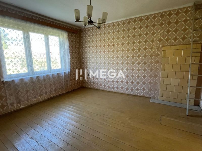Na PREDAJ - Dom s krásnym pozemkom v Zbudskej Belej - Rodinný dom s podlahou s dreveným dekorom, vzorovanými tapetami a veľkým oknom.