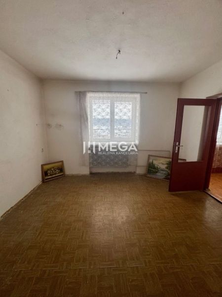 NA PREDAJ PRIESTRANNÝ RODINNÝ DOM OBEC MYSLINA - Izba v rodinnom dome s podlahou s dreveným dekorom a obrazmi opretými o stenu.