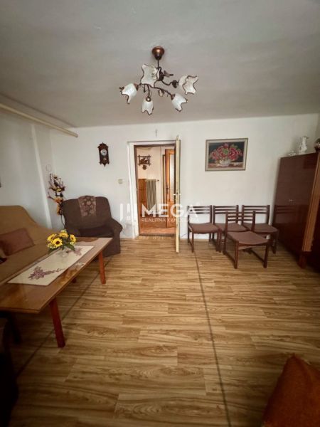 NA PREDAJ PRIESTRANNÝ RODINNÝ DOM OBEC MYSLINA - Obývacia izba v rodinnom dome s podlahou s dreveným dekorom a nábytkom.