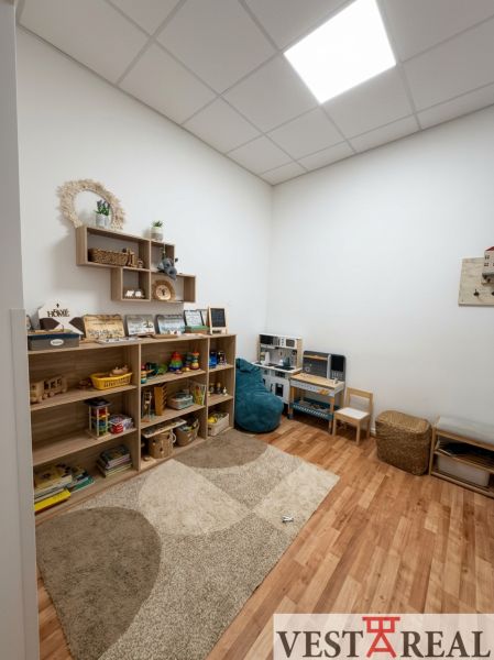 Na prenájom kancelársky priestor 30 m² – Trnava Františkánska - Detský kútik v kancelárii s regálmi plnými hračiek, podlaha s dreveným dekorom.