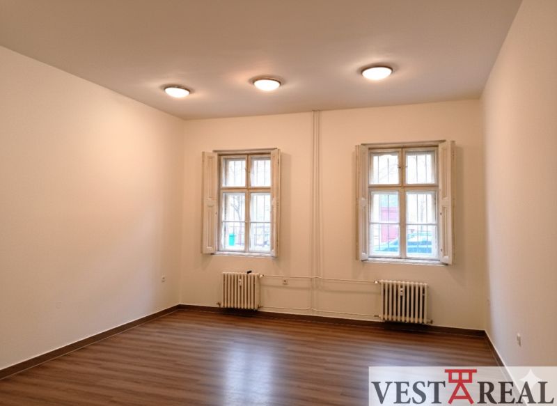 Na prenájom kancelársky priestor 30 m² – Trnava Františkánska - Miestnosť s dvoma oknami, bielymi stenami a podlahou s dreveným dekorom. Kancelárie.