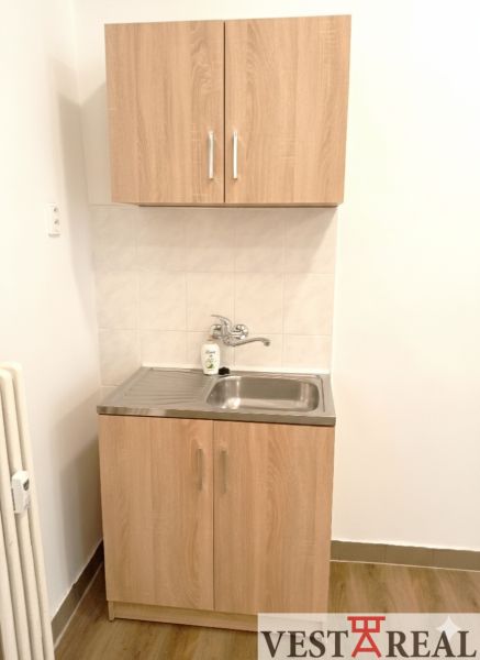 Na prenájom kancelársky priestor 30 m² – Trnava Františkánska - Malá kuchynská linka s umývadlom a skrinkami, podlaha s dreveným dekorom.