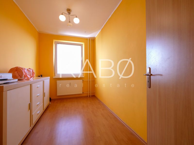 Kompletne zariadený 3 izbový byt s loggiou - Petzwalova ulica  - Izba v 3-izbovom byte s oranžovými stenami a podlahou s dreveným dekorom.