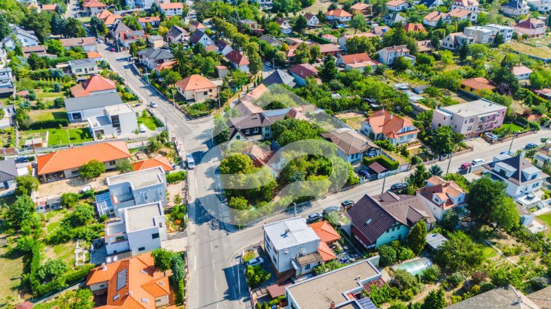 Predaj 6 izbový dom s veľkým rožným pozemkom Nitra, Zobor - Letecký pohľad na rodinné domy na ulici Chmeľová dolina v Nitre, obklopené zeleňou.
