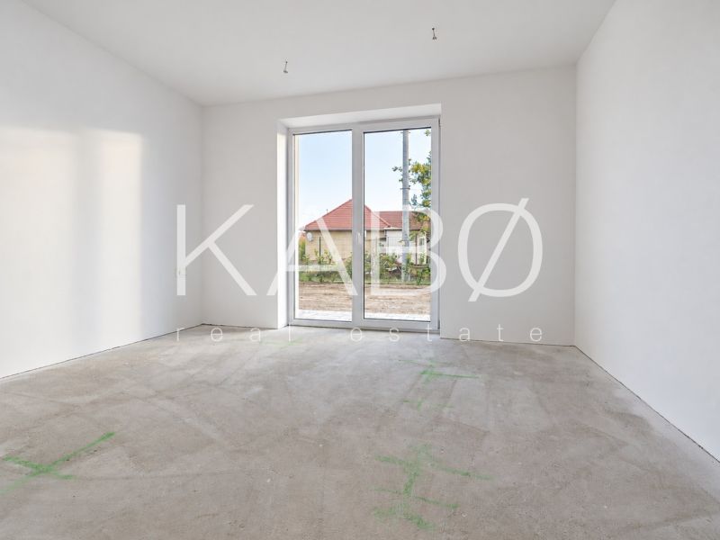 Posledný Voľný - Moderný 4-izbový rodinný dom s terasou a záhradou - Prázdna izba s veľkým oknom v rodinnom dome, podlaha pripravená na dokončenie.