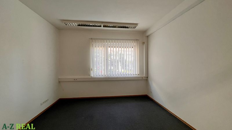 Prenájom kancelárskych priestorov Ružinov, 100 m2,  parking - Interiér kancelárie s oknom a vertikálnymi žalúziami; čierne kobercové podlahy.