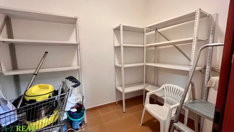 Prenájom kancelárskych priestorov Ružinov, 100 m2,  parking - Úložný priestor s regálmi, biela plastová stolička a kovový rebrík.