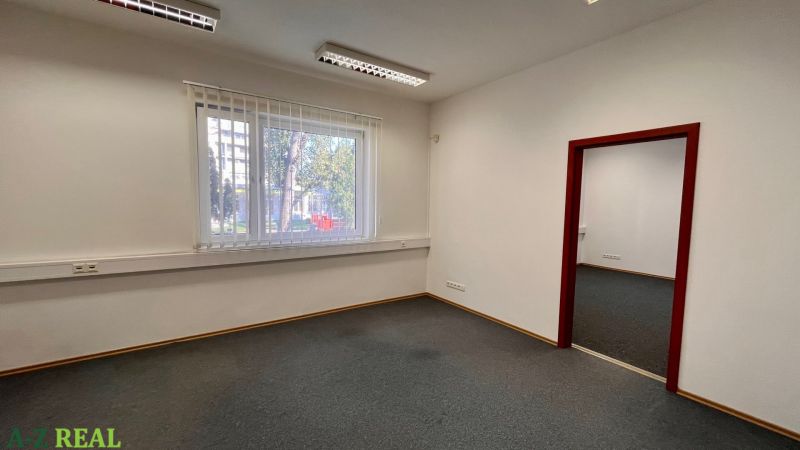 Prenájom kancelárskych priestorov Ružinov, 100 m2,  parking - Kancelárie s kobercovou podlahou a veľkým oknom, biele steny, žalužie.