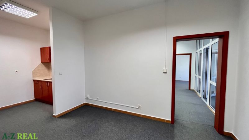 Prenájom kancelárskych priestorov Ružinov, 100 m2,  parking - Kancelárie so šedým kobercom a výhľadom na kuchynský kút.