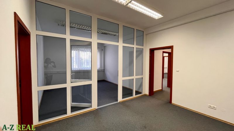 Prenájom kancelárskych priestorov Ružinov, 100 m2,  parking - Kancelárie s presklenými stenami a tmavým kobercom na podlahe.