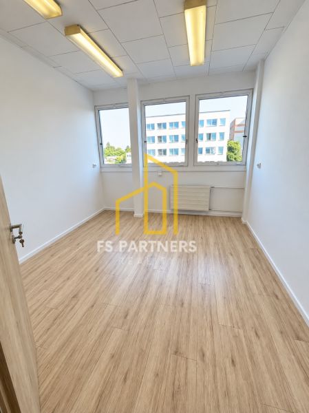 PRENÁJOM KANCELÁRIE 13,5 m² – KOMÁRNO, ZÁHRADNÍCKA ULICA - Kancelária s podlahou s dreveným dekorom, interiér s veľkými oknami a stropným osvetlením.