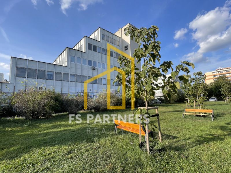 PRENÁJOM KANCELÁRIE 13,5 m² – KOMÁRNO, ZÁHRADNÍCKA ULICA - Kancelárie na Záhradníckej ulici v Komárne s lavičkami a mladými stromami.