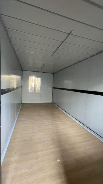 NUERA I PREDAJ - Záhradný domček/ Sklad alebo dieľňa - Interiér chaty s podlahou s dreveným dekorom, bielymi stenami a malým oknom.